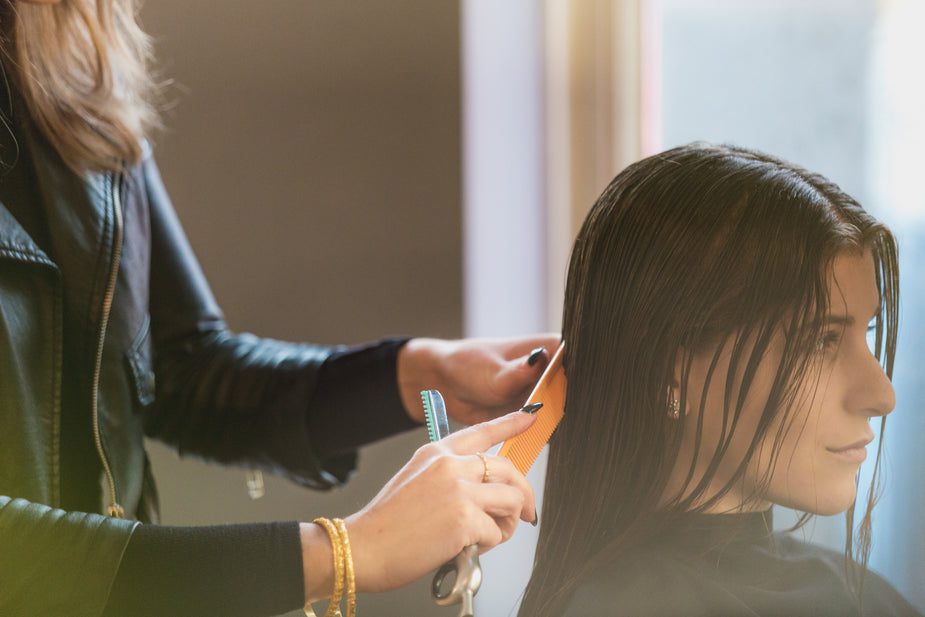 hair stylist combing womans hair